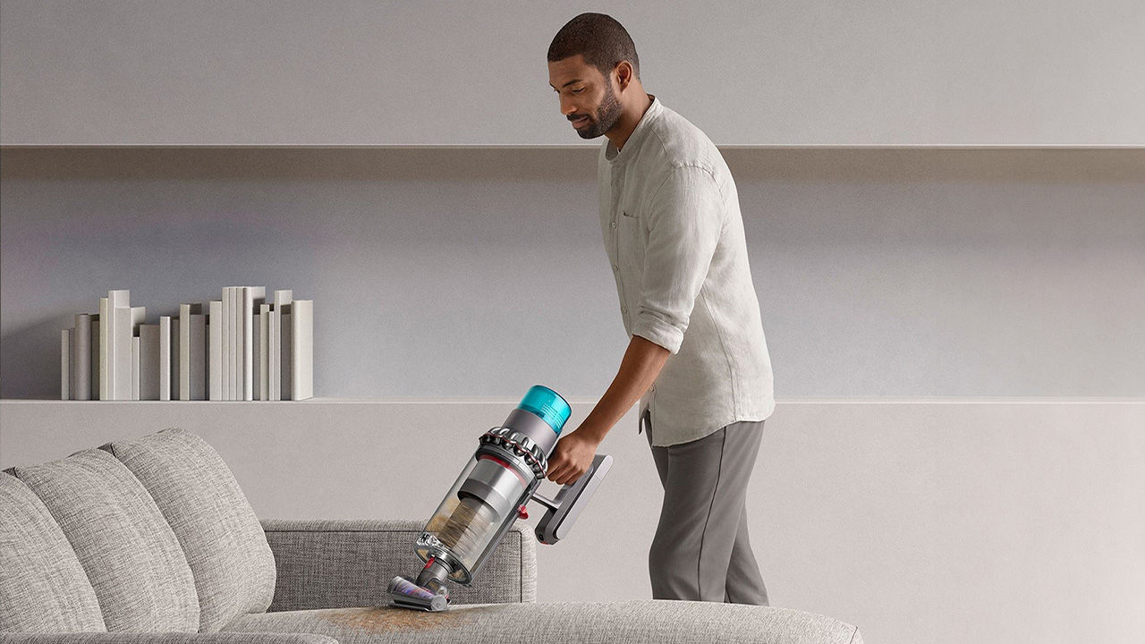 Man vacuuming a sofa