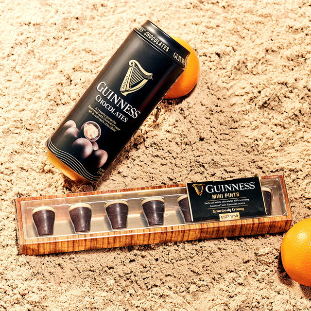 A can of Guinness and Guinness chocolates on the beach