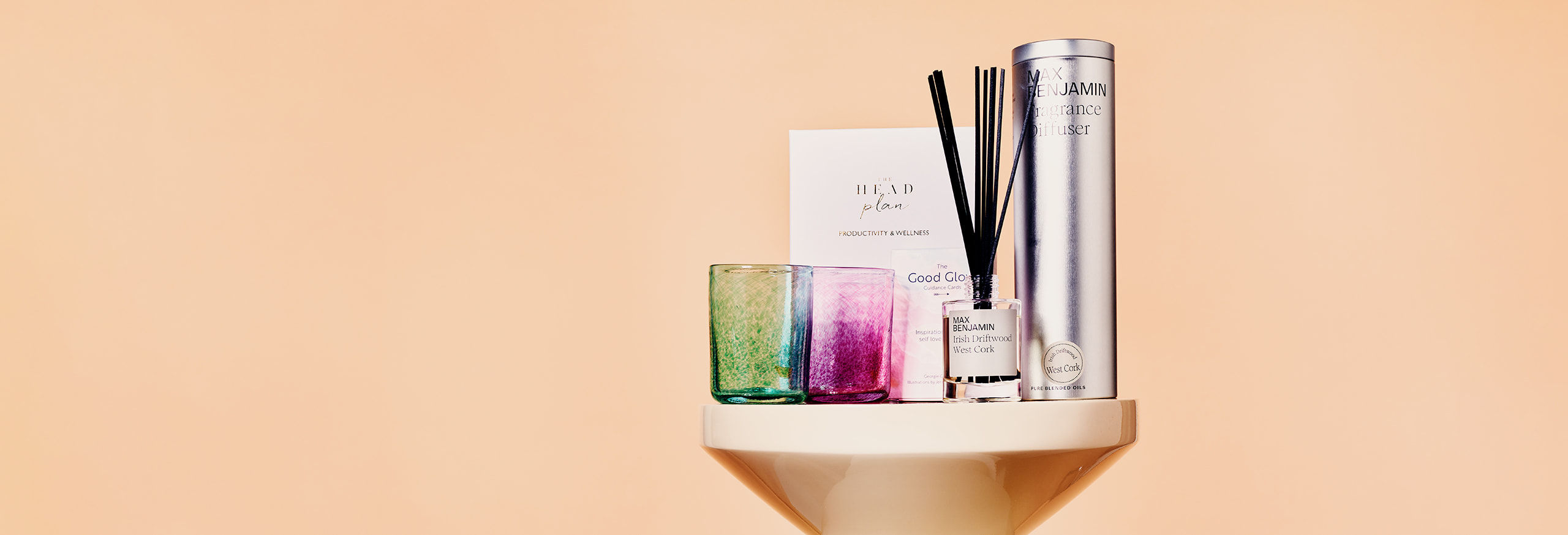 candles and a diffuser on a marble stand
