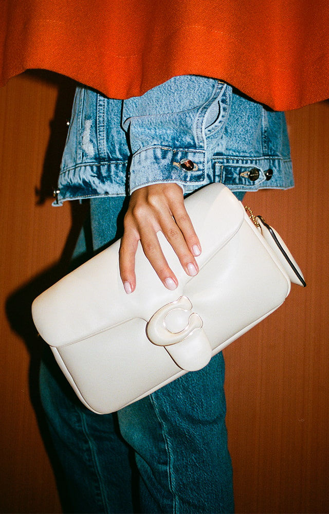 woman holding white handbag