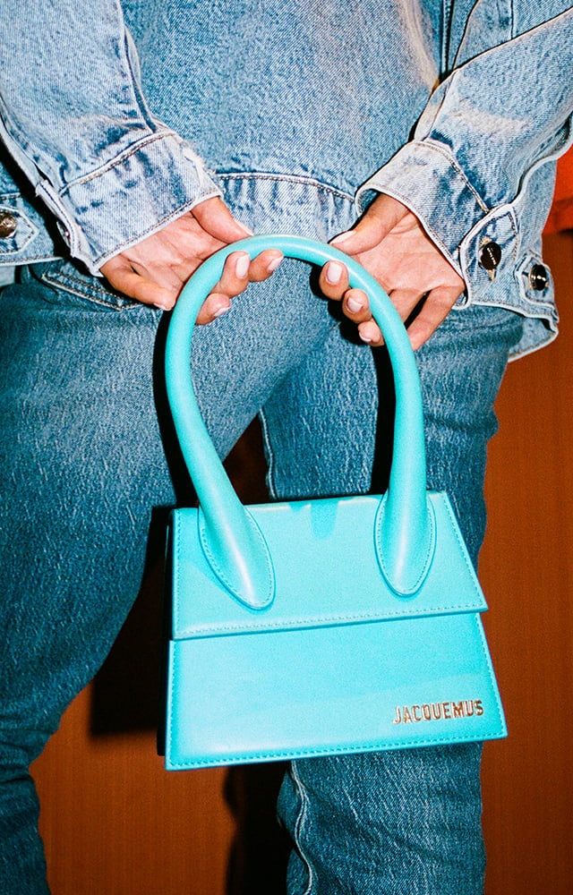 woman holding blue Jacquemus handbag