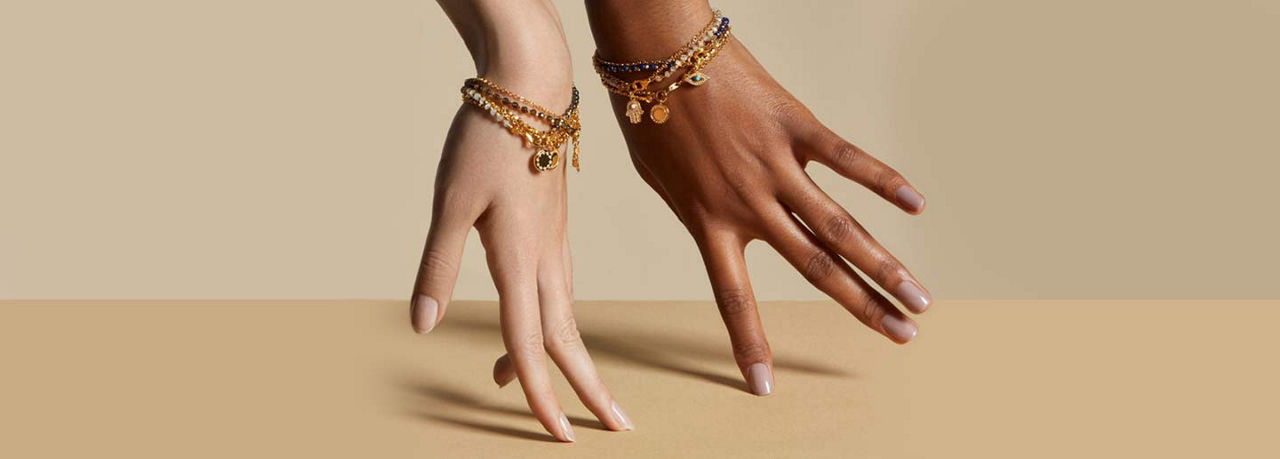 two women's hands wearing bracelets