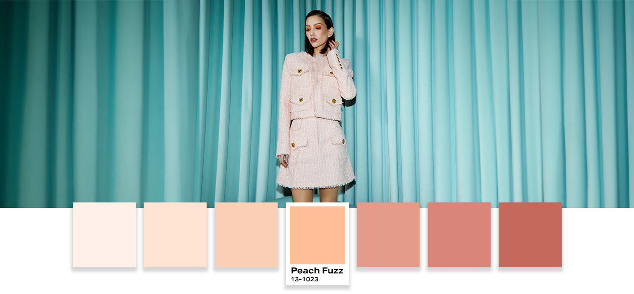 women in blue curtains with peach pantone